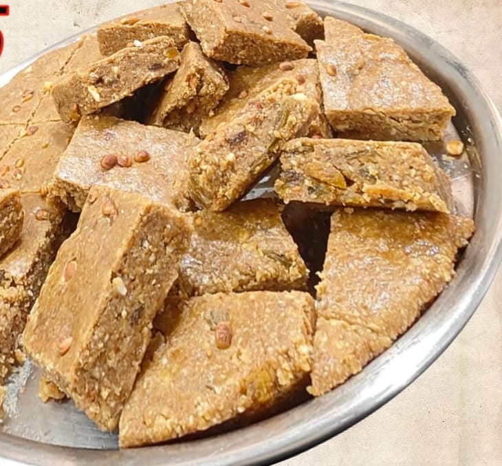Diamond-cut pieces of almond badam pak on a steel plate