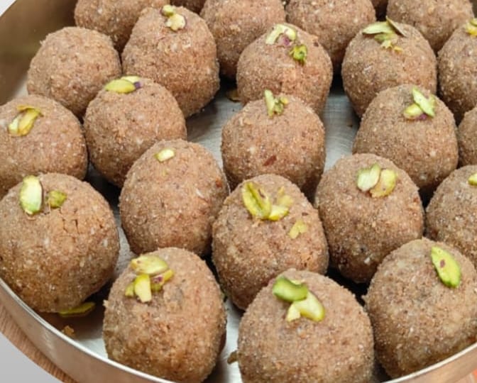 Quinoa laddoos topped with slivered pistachio in a steel plate