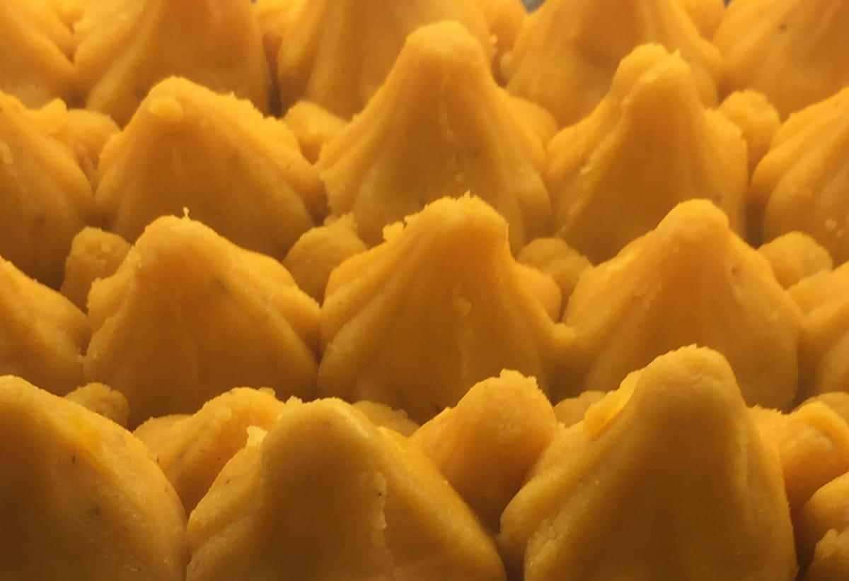 Rows of golden saffron modak in the classic pleated cone shape