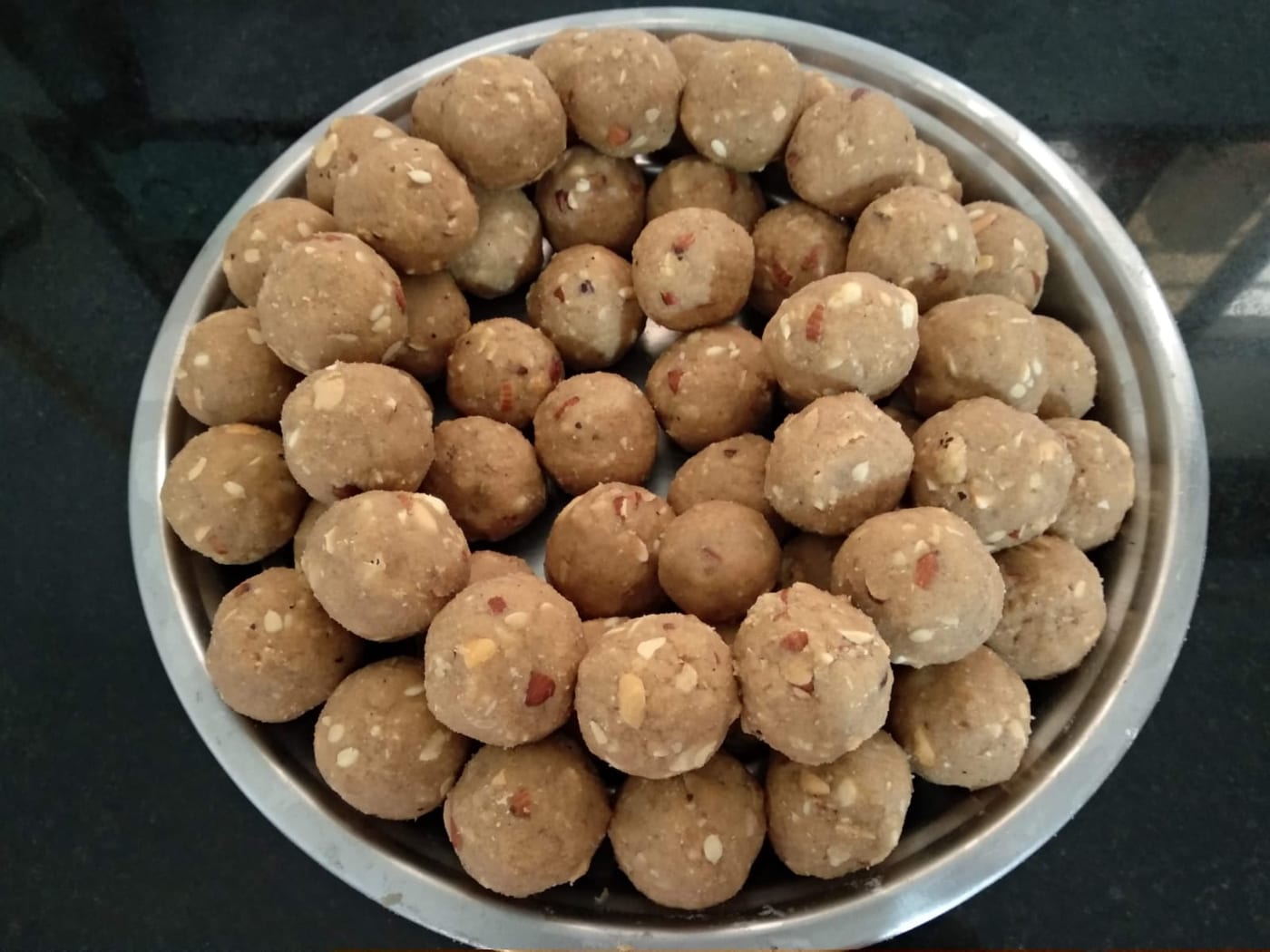 Pale, nutty panjeeri laddoos in a steel bowl
